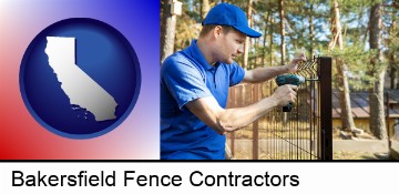 fence builder attaching fencing to a fence post in Bakersfield, CA